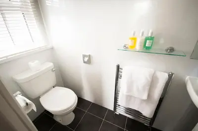 a bathroom with a toilet and a sink and towels at Crown Hotel Wetheral in Carlisle