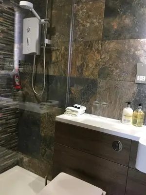a bathroom with a shower and a toilet and a sink at Inverlea Guest House in Ayr