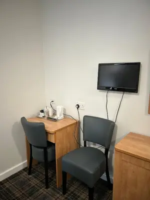 a room with a desk and two chairs and a tv at Adamton Country House Hotel in Prestwick