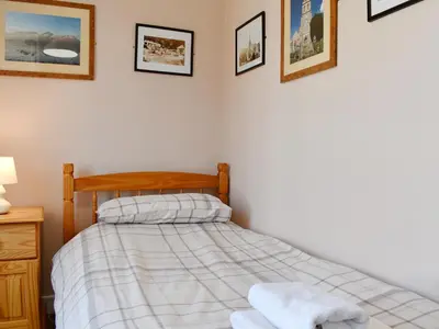 a bedroom with a bed and pictures on the wall at Oak Apple House in Keswick
