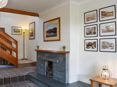 a living room with a fireplace and pictures on the wall at Oak Apple House in Keswick