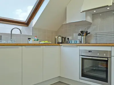 a kitchen with white cabinets and a sink at Herdwick Heights in Keswick