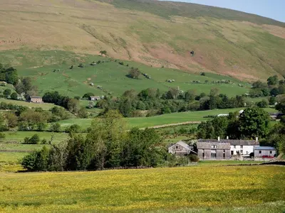 an old house in a field with a hill at Blencathra in Mungrisdale