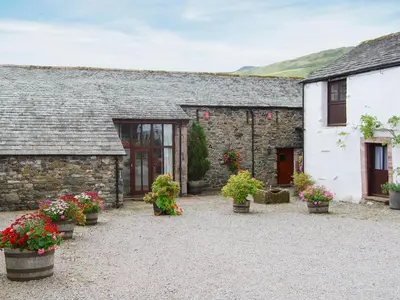 a stone building with potted plants in front of it at Blencathra in Mungrisdale