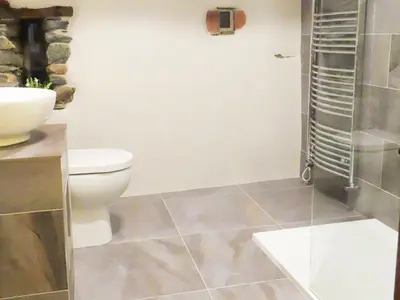a bathroom with a toilet and a glass shower at The Garth in Mungrisdale