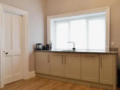 a kitchen with a sink and a large window at Bag End in Keswick