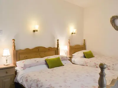 a bedroom with two beds with green pillows at Harriet's Hideaway in Braithwaite