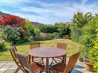a wooden table and chairs in a garden at Heatherside in Portinscale