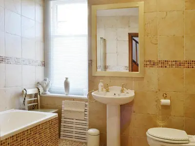 a bathroom with a sink and a toilet and a tub at Oak Lea in Keswick