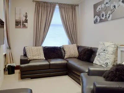 a leather couch in a living room with a window at Oak Lea in Keswick