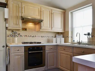 a kitchen with wooden cabinets and a stove top oven at Oak Lea in Keswick