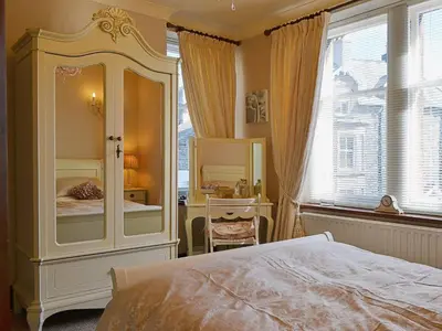 a bedroom with a large white dresser with a mirror at Oak Lea in Keswick