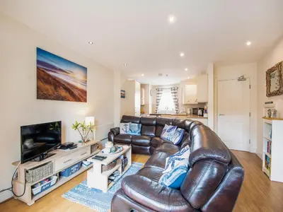 a living room with a leather couch and a television at Harbour Retreat in Garlieston