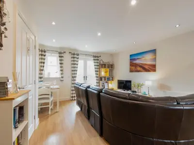 a living room with a large leather couch at Harbour Retreat in Garlieston