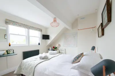 a bedroom with a white bed and a window at The Mount B&B in Keswick
