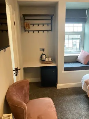 a room with a bed and a desk and a window at Abbey Court Guest House in Carlisle