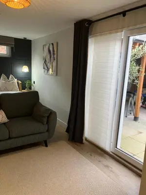 a living room with a couch and a sliding glass door at Abbey Court Guest House in Carlisle