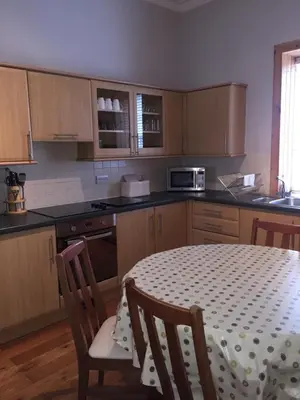 a kitchen with a table with two chairs and a table and a kitchen with at Old Station House - Kilfillan Cottage in Garlieston