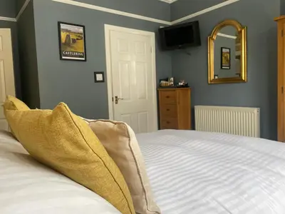 a bedroom with a bed and a mirror and a television at Glendale Guest House in Keswick