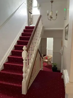 a red carpeted staircase with a red carpeted stair case at Glendale Guest House in Keswick