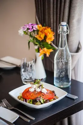 a plate of food on a table with a vase with flowers at Mannin Hotel in Douglas