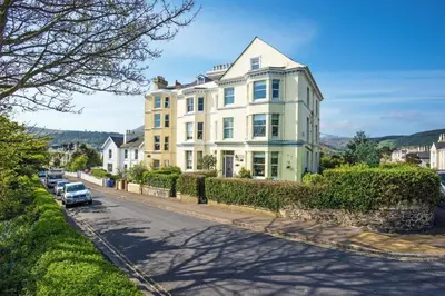 a large white house on the side of a street at Baie Mooar House, Boutique B&B in Ramsey