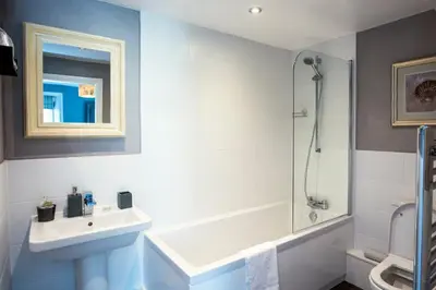 a white bathroom with a sink and a shower at Baie Mooar House, Boutique B&B in Ramsey