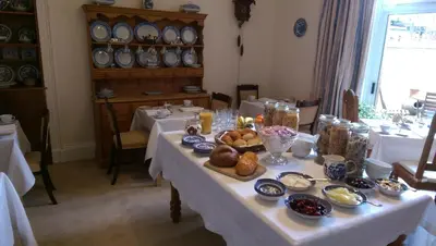 a dining room with a table with food on it at Lochinver Guesthouse in Ayr