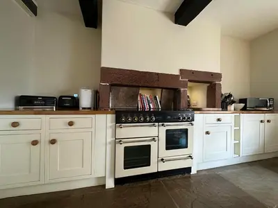 a kitchen with white cabinets and a black oven at Ann's Hill in Cockermouth