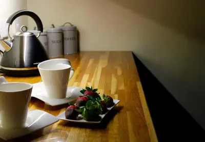 a table with two cups and a plate of food at Ann's Hill in Cockermouth
