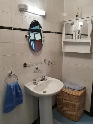 a bathroom with a white sink and a mirror at Crailloch Croft Cottages in Stranraer