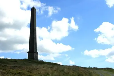 a monument on top of a hill with a cloudy sky at The Douglas Hotel in Langholm