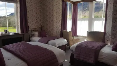 a hotel room with two beds and windows at The Old Dungeon Ghyll Hotel in Great Langdale