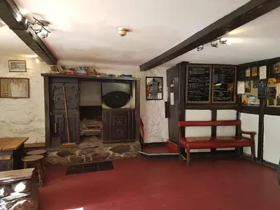 a room with a bench and a chair in a restaurant at The Old Dungeon Ghyll Hotel in Great Langdale