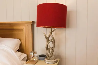 a lamp on a night stand next to a bed at Sea View Snugs at Laggan in Gatehouse of Fleet