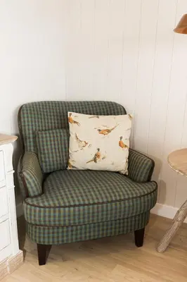 a green chair with a pillow in a room at Sea View Snugs at Laggan in Gatehouse of Fleet