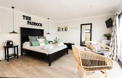 a bedroom with a bed and two chairs at Sea View Snugs at Laggan in Gatehouse of Fleet