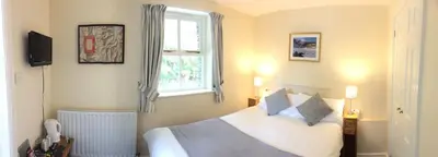 a bedroom with a white bed and a window at Old Water View in Patterdale