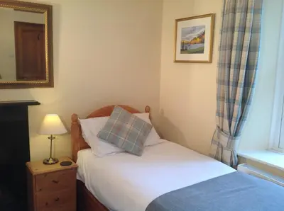 a small bedroom with a bed and a window at Old Water View in Patterdale