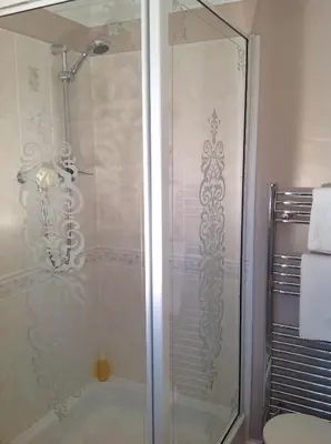 a shower with a glass door in a bathroom at Old Water View in Patterdale