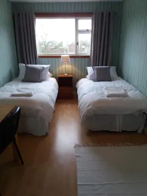 two beds in a room with a window at House for Groups & Contractors Kilmarnock in Kilmarnock