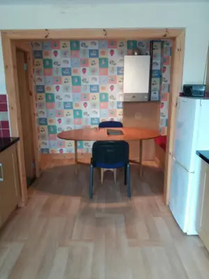 a small kitchen with a table and a refrigerator at House for Groups & Contractors Kilmarnock in Kilmarnock