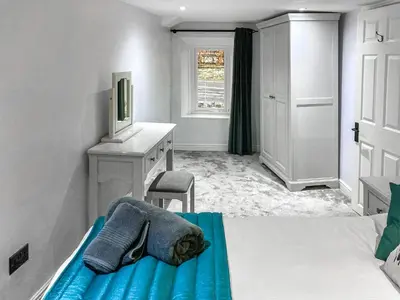 a bedroom with a bed and a desk and a desk at Cosy Cottage in Portinscale