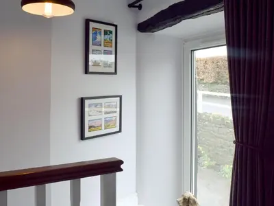 a room with a window with pictures on the wall at Cosy Cottage in Portinscale
