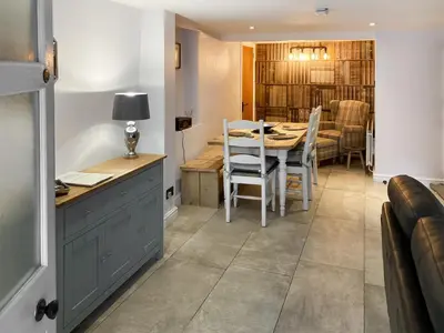 a kitchen and dining room with a table and chairs at Cosy Cottage in Portinscale