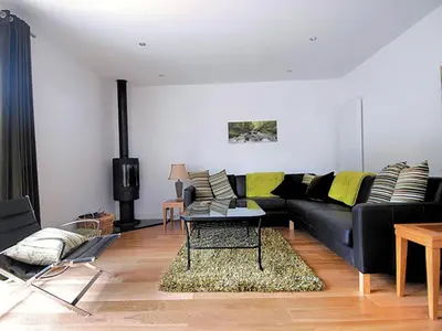 a living room with a black couch and yellow pillows at Island View in Dunure
