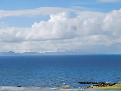 a view of the ocean with mountains in the distance at Island View in Dunure