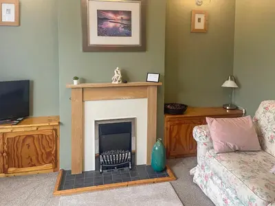 a living room with a fireplace and a couch at Bay Cottage in Keswick