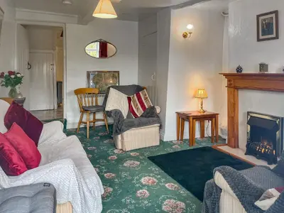 a living room with two couches and a fireplace at Ingle Neuk Cottage in Mosedale