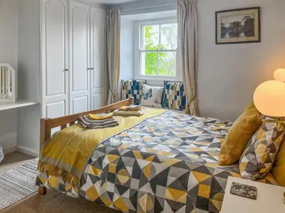 a bedroom with a bed and a window at Ingle Neuk Cottage in Mosedale